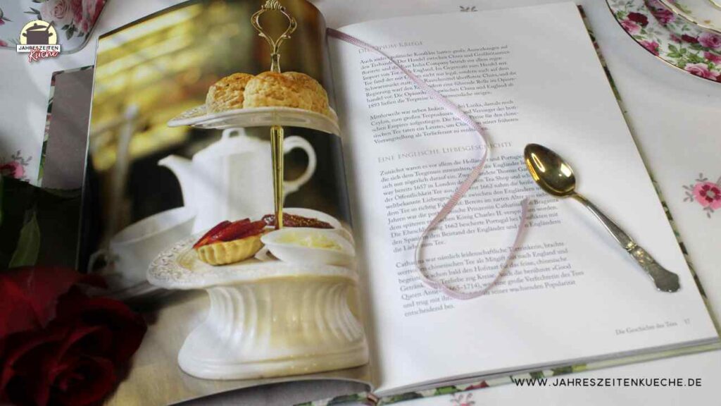 Das aufgeschlagene Buch A very british Teat Time zeigt eine Seite mit der Geschichte des Tees. Darauf liegt ein kleiner Silberlöffel.