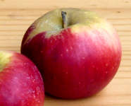 ein roter Apfel auf einer Holzplatte