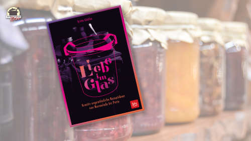 Das Buch Liebe im Glas von Britta Gädtke ist im Vordergrund. Im Hintergrund sind Marmeladengläser aufgereiht.