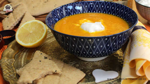 Marokkanische Karottensuppe, die mit Ras-el-Hanout gewürzt ist, in einer Schüssel, die auf einem Messingtablett steht.