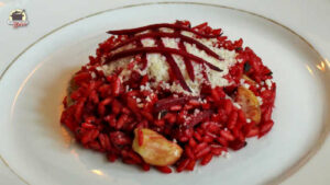 Rote Bete-Risotto mit Maronen auf einem weißen Teller.