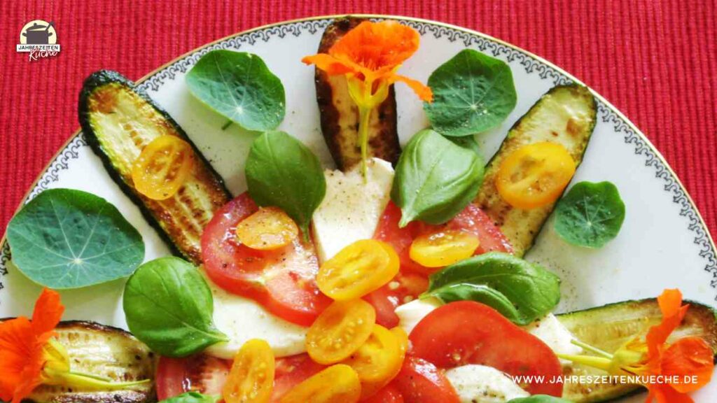 Tomate, Basilikum und Mozzarella sind als schneller Salat auf einem Teller angerichtet