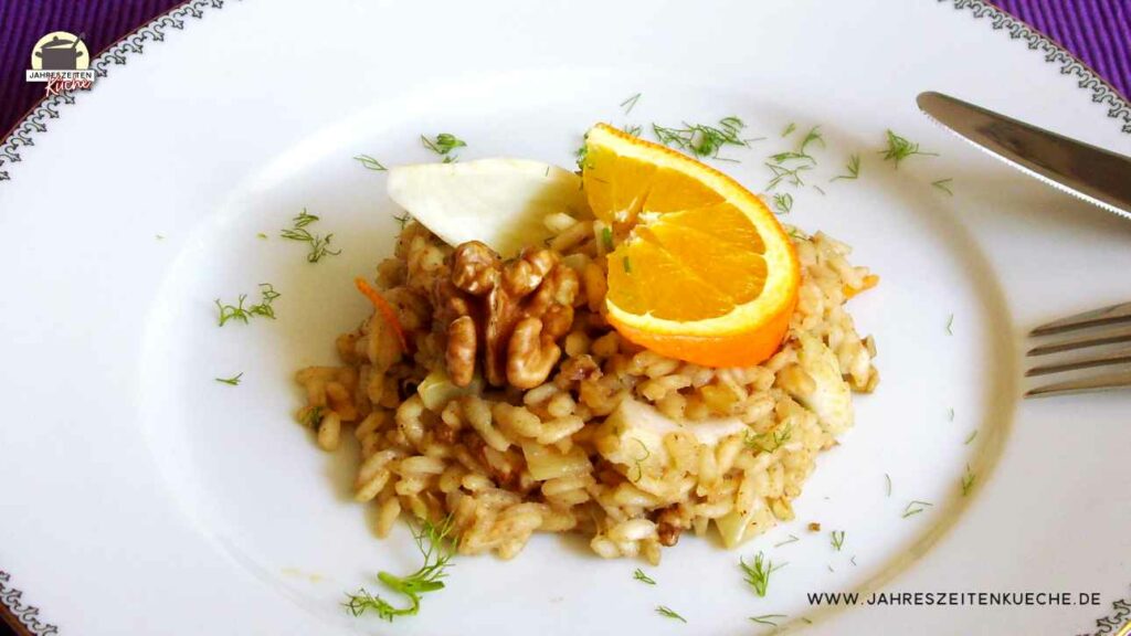Veganes Winter-Risotto mit einer Orangenscheibe auf einem weißen Teller