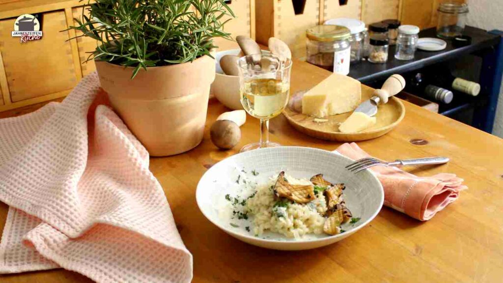 Auf einem Holztisch ist ein Teller mit Kräuterseitling-Risotto dekoriert.