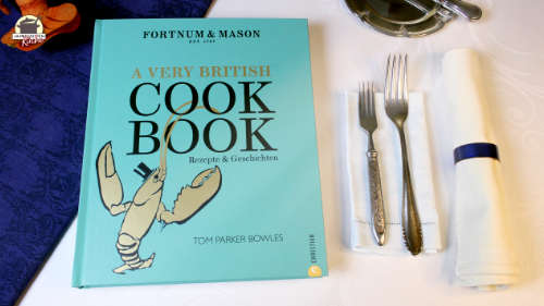 Neben dem Buch von Tom Parker Bowles "A Very Britisch Cookbook liegen zwei Gabeln und eine Stoffserviette