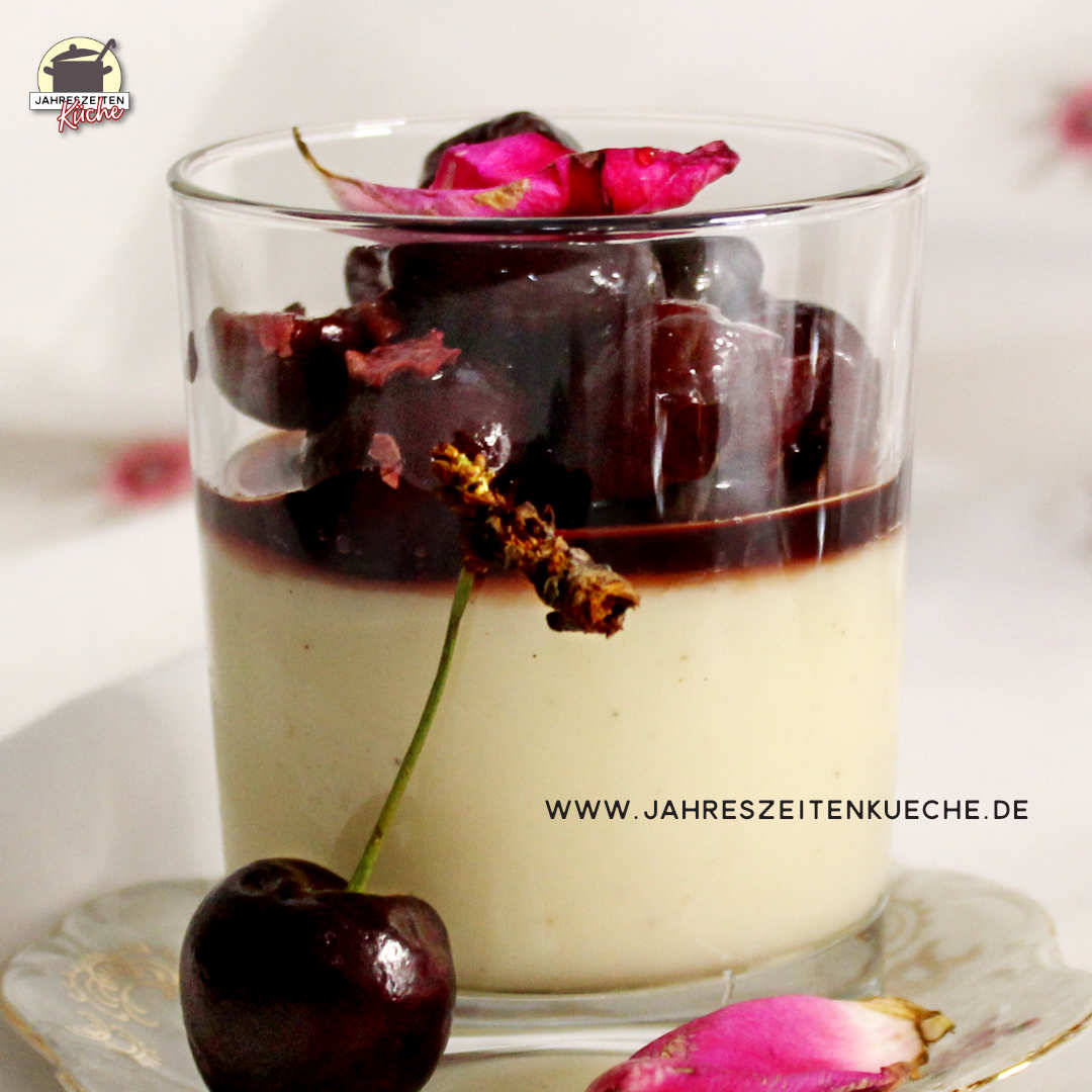 Vanille-Pudding mit Rosen-Kirsch-Kompott ist mit einer Rosenblüte dekoriert.