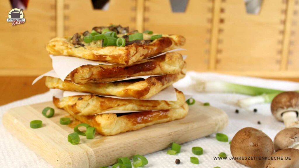 Ein Stapel Blätterteig-Snacks mit Champignons und Frühlingszwiebeln