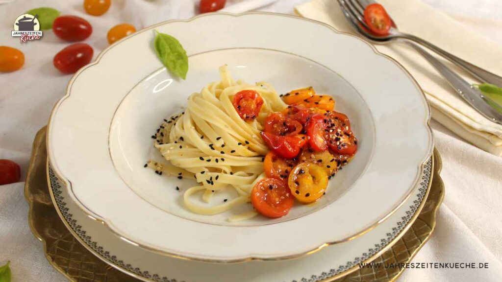 Ein tiefer Teller mit Fettuccine und glasierten Tomaten