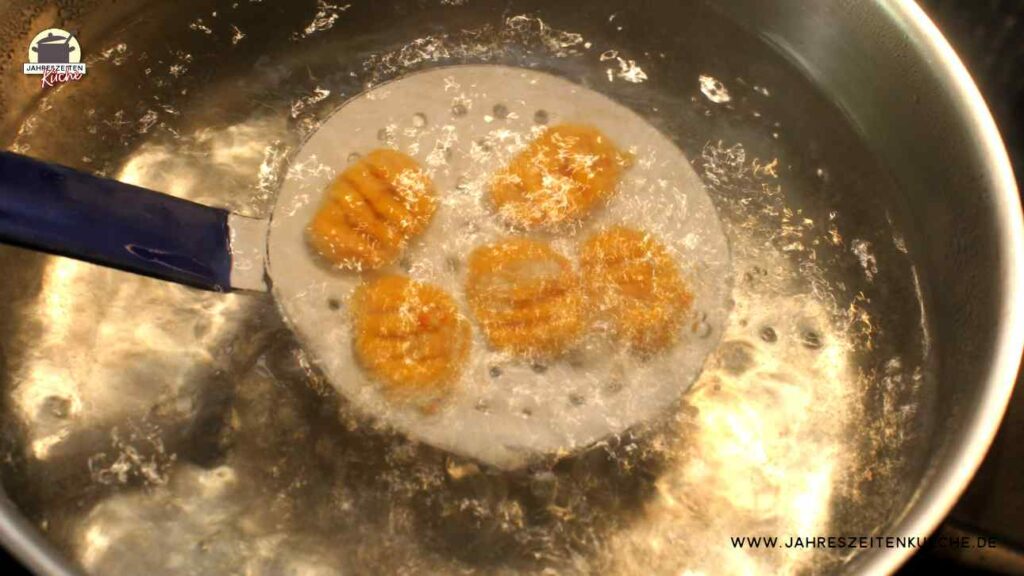Frische Gnocchi werden mit einem Schaumlöffel in kochendes Wasser gelegt