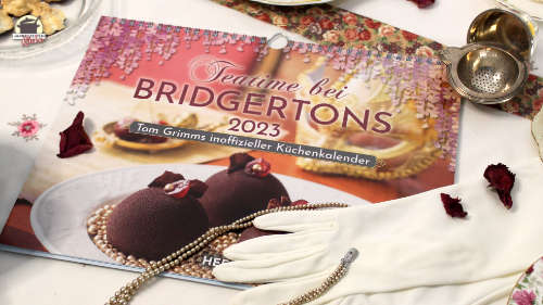 Auf dem neuen Kalender Teatime bei Bridgertons liegt ein Paar weißen Handschuhe und eine Perlenkette.