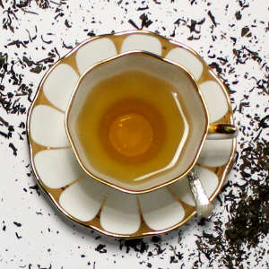Eine geoldgemusterte weiße Tasse mit Tee