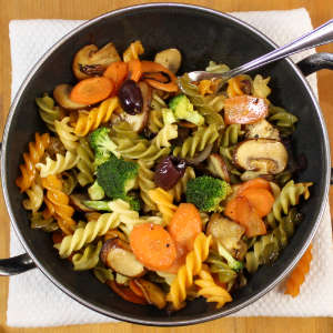 Eine Gemüse-Nudelpfanne mit Brokkoli, Champignons und Karotten in der Draufsicht