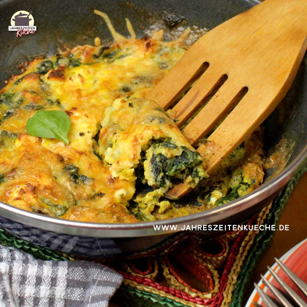 Gebackenes Spinat-Frittata in einer Pfanne mit Holzlöffel