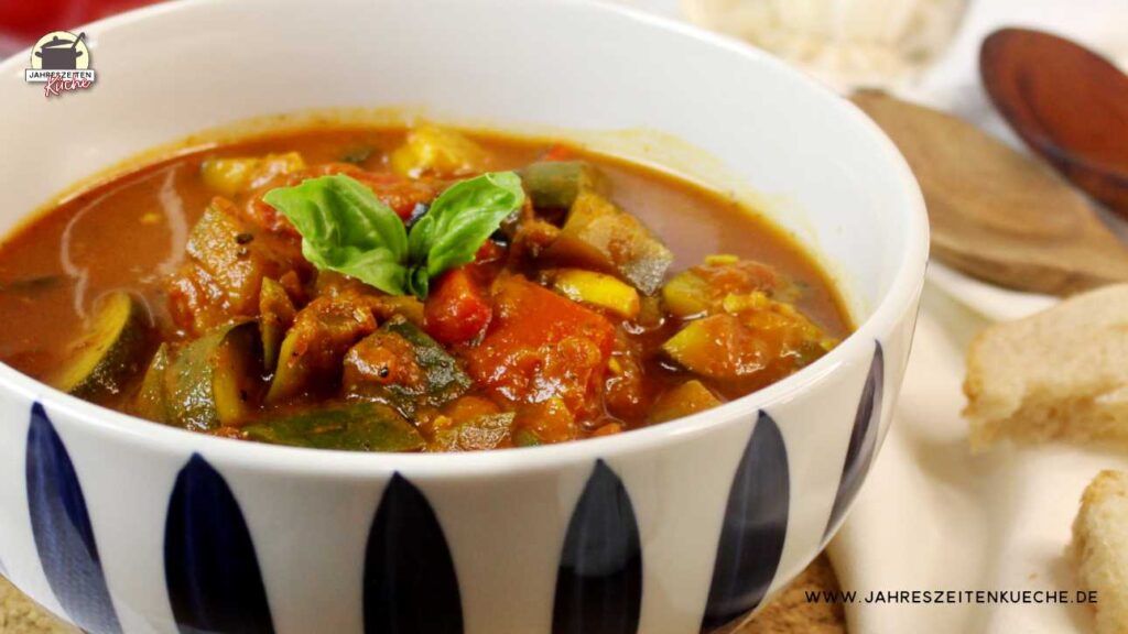 Eine Porzellanschale mit französicher Ratatouille, dekoriert mit Basilkum-Blättern