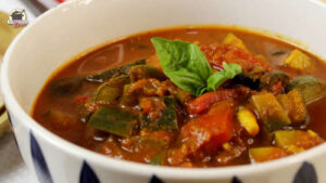 Eine Porzellanschale mit französicher Ratatouille, dekoriert mit Basilkum-Blättern