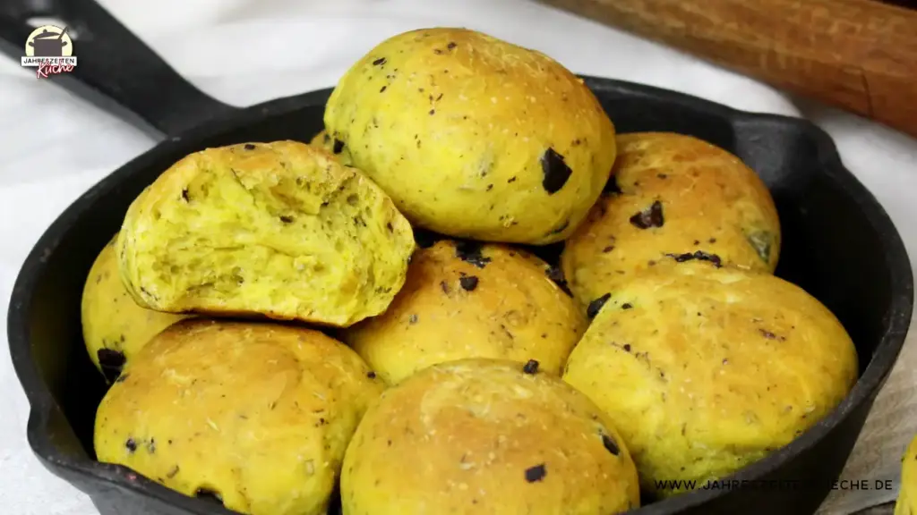 Partybrötchen mit schwarzen Oliven in einer Gusseisenpfanne