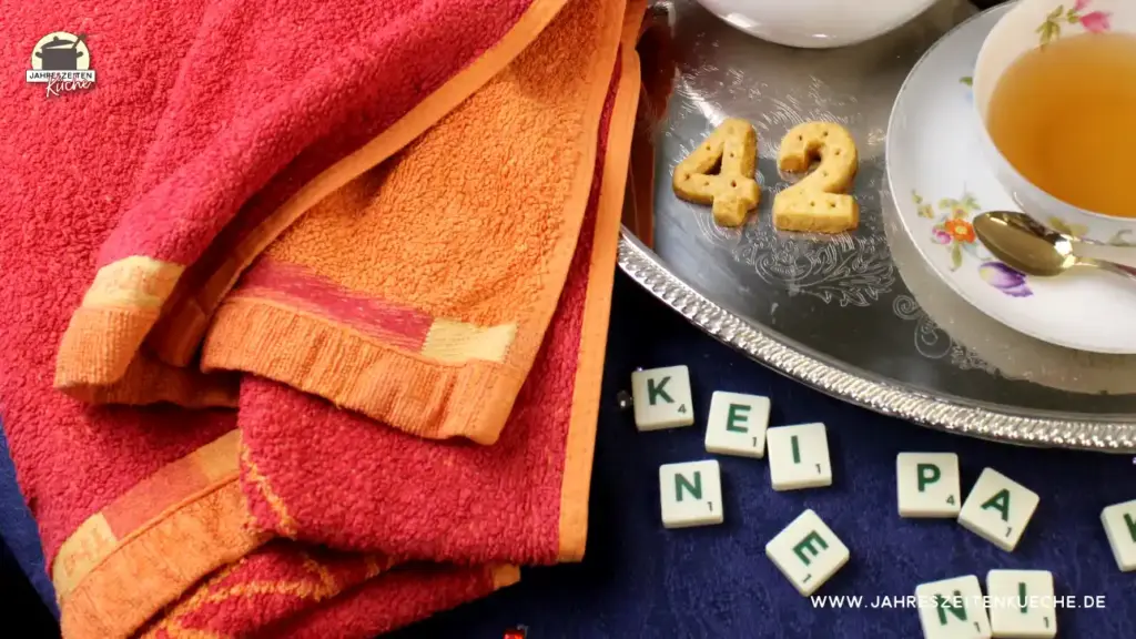 Shortbread in der Form von 42 auf einem silbernen Teller. Links daneben ein Handtuch