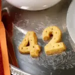 Shortbread in der Form von 42 auf einem silbernen Teller. Links daneben ein Handtuch