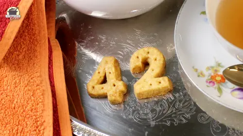 Shortbread in der Form von 42 auf einem silbernen Teller. Links daneben ein Handtuch