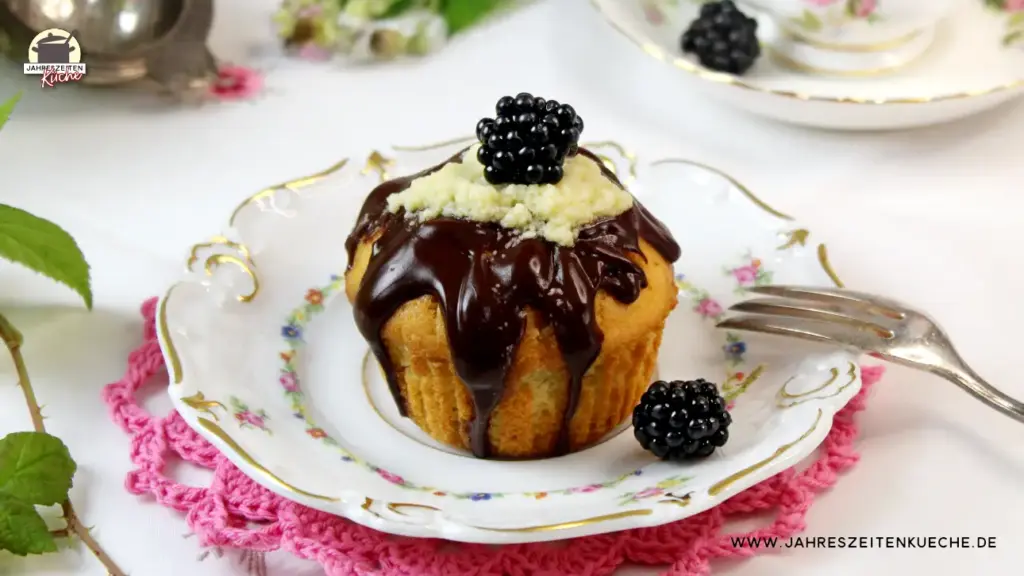 Ein Muffin mit Brombeer Curd-Füllung auf einem kleinen Porzellanteller