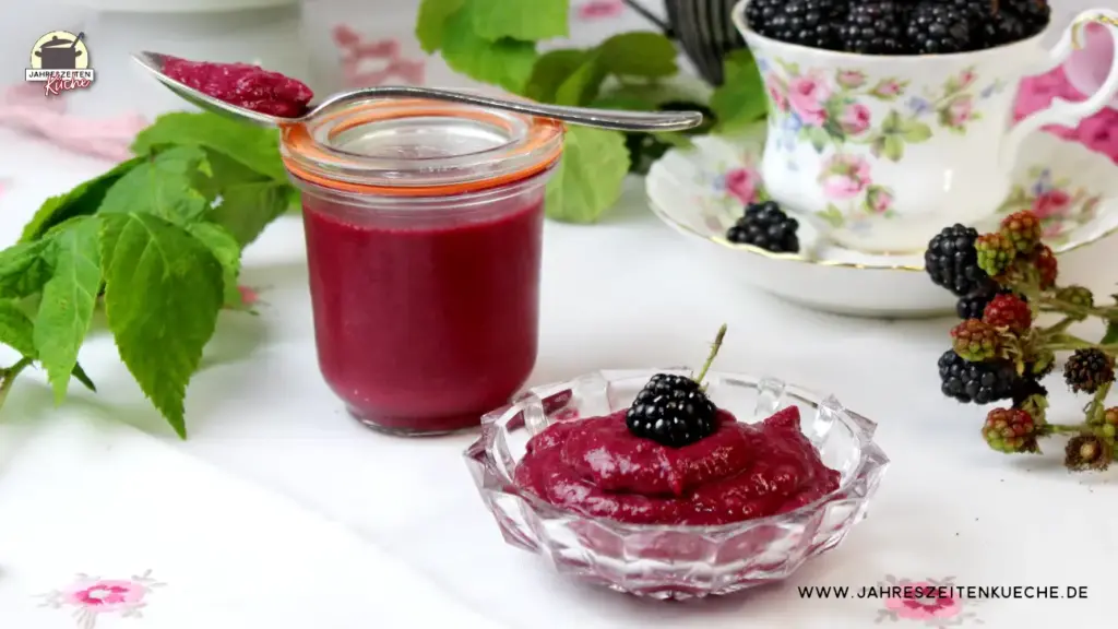 Ein Glas und ein Schälchen mit Brombeer Curd gefüllt. Daneben ein Zweig mit frischen Brombeeren