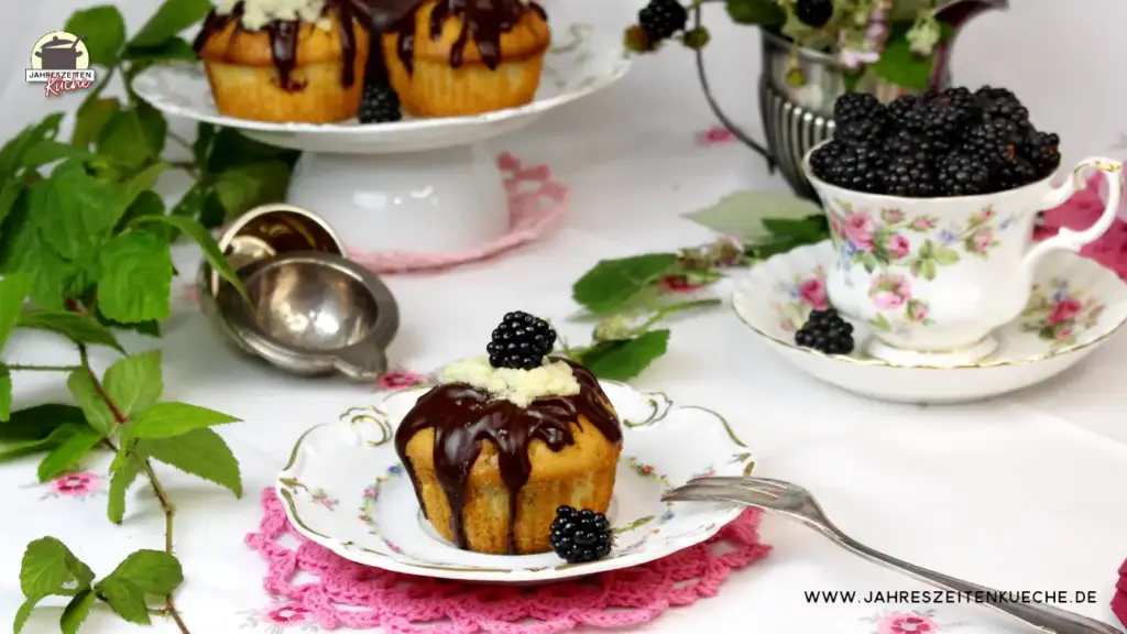Gedeckter Tisch mit Brombeer-Muffins, Brombeeren und Brombeerzweigen