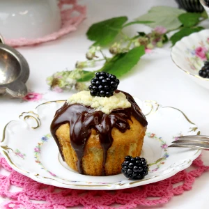 Ein Muffin mit Brombeer Curd-Füllung auf einem kleinen Porzellanteller