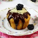 Ein Muffin mit Brombeer Curd-Füllung auf einem kleinen Porzellanteller